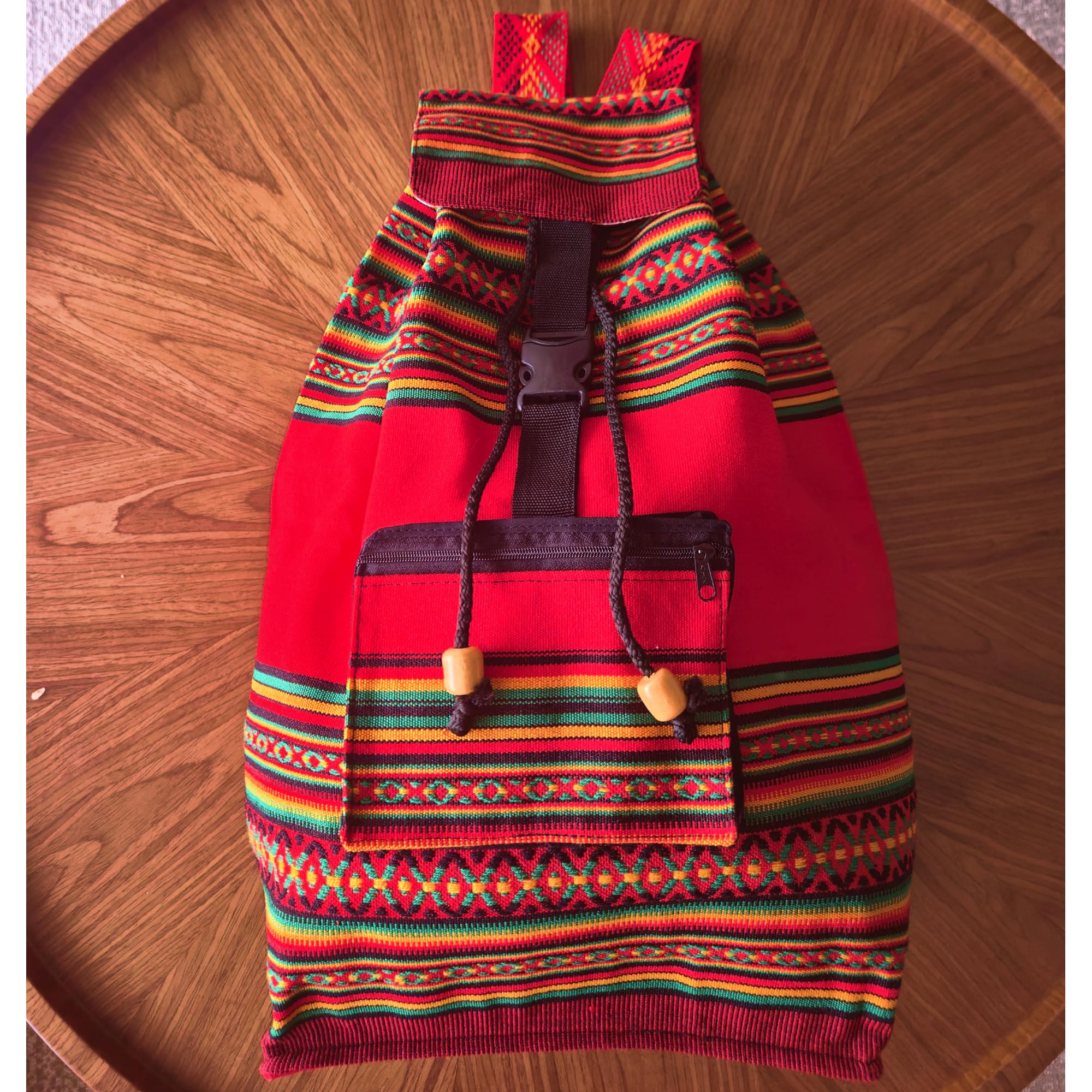 Colorful backpack with red base on a wooden surface