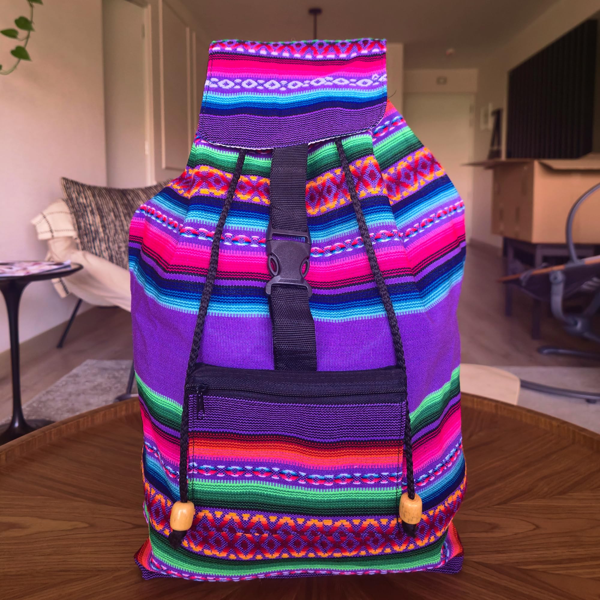 Colorful striped bag with patterns on a wooden floor in a room.