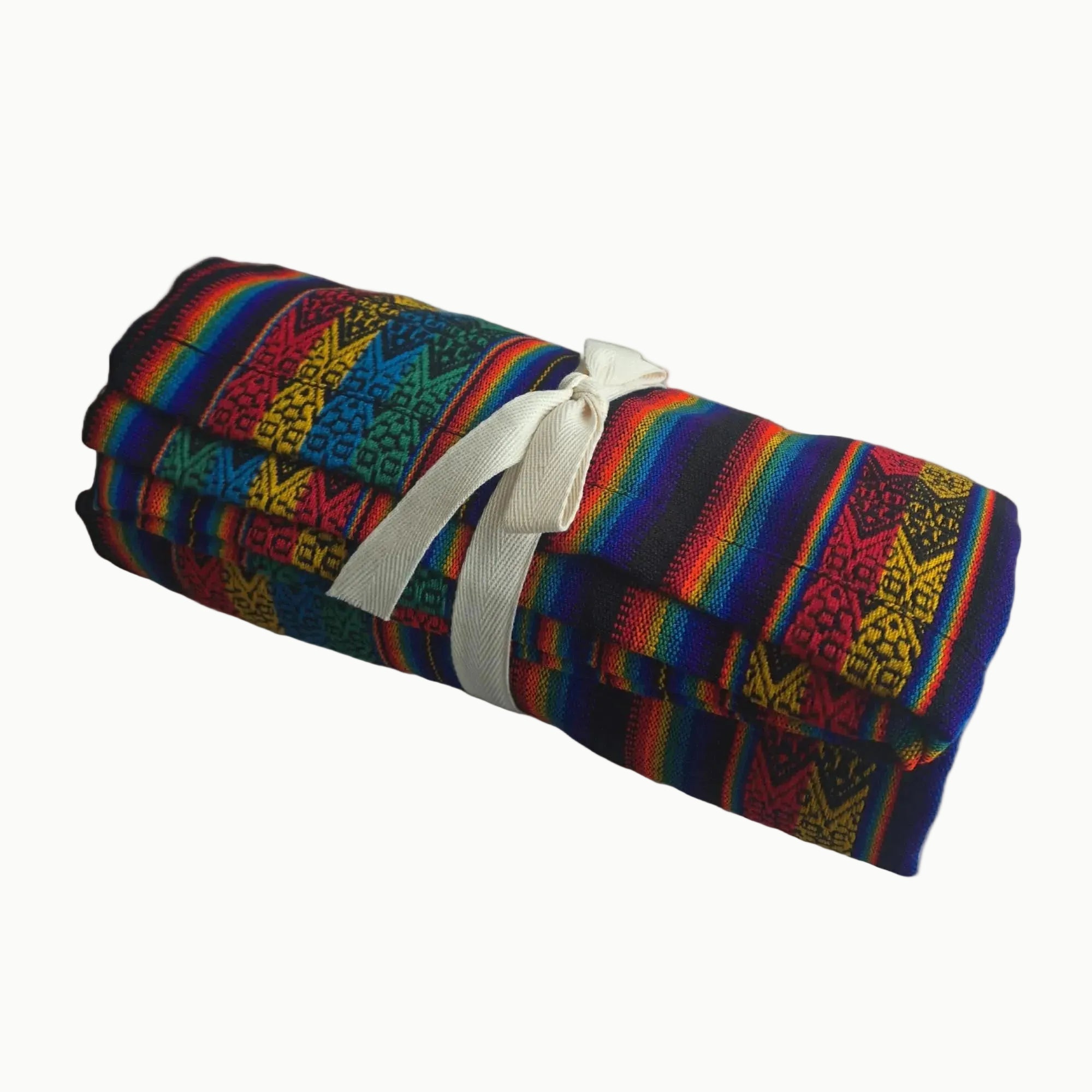 Colorful woven blanket with geometric patterns rolled up and tied with a white ribbon on a white background.