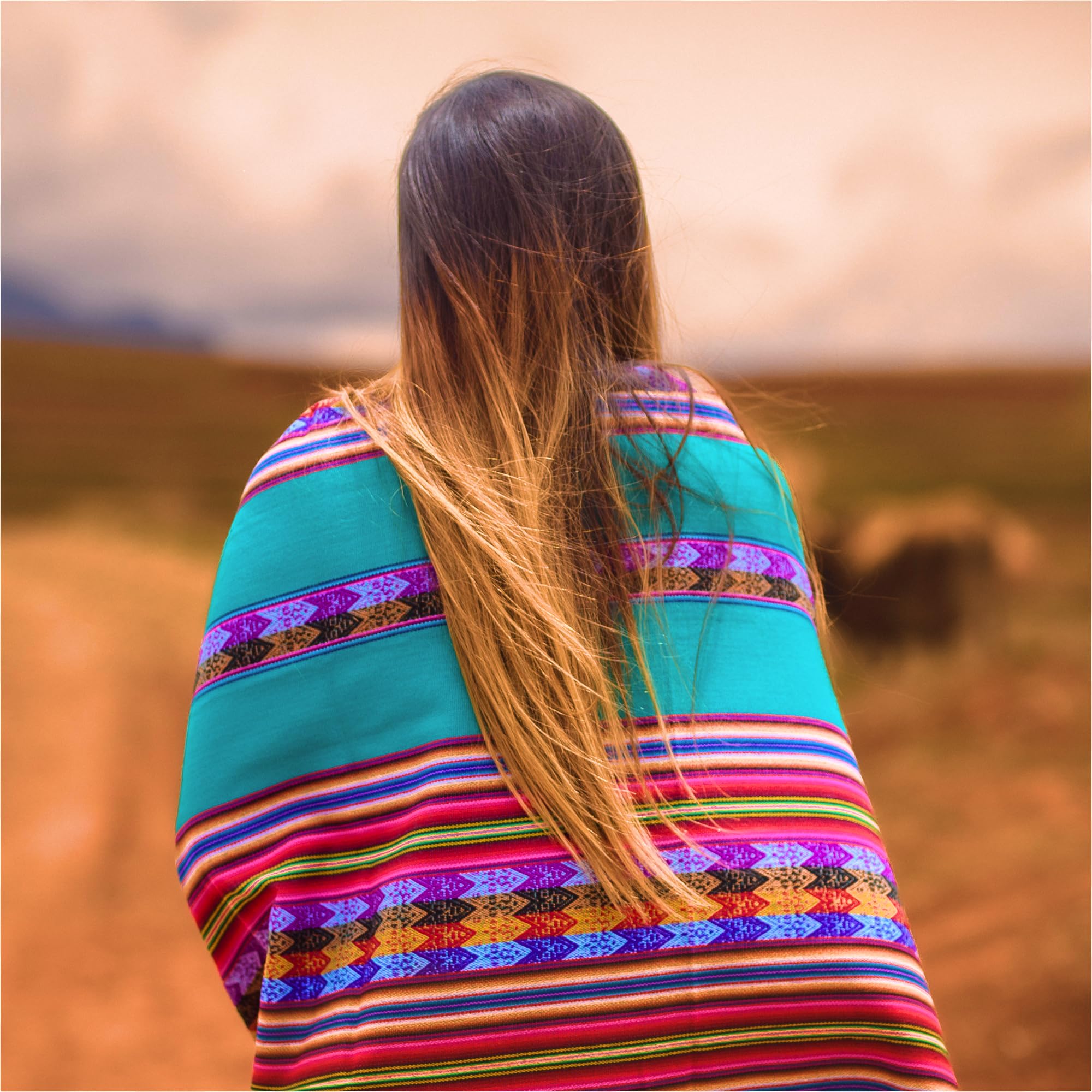 Person wearing a colorful traditional garment with a blurred natural background
