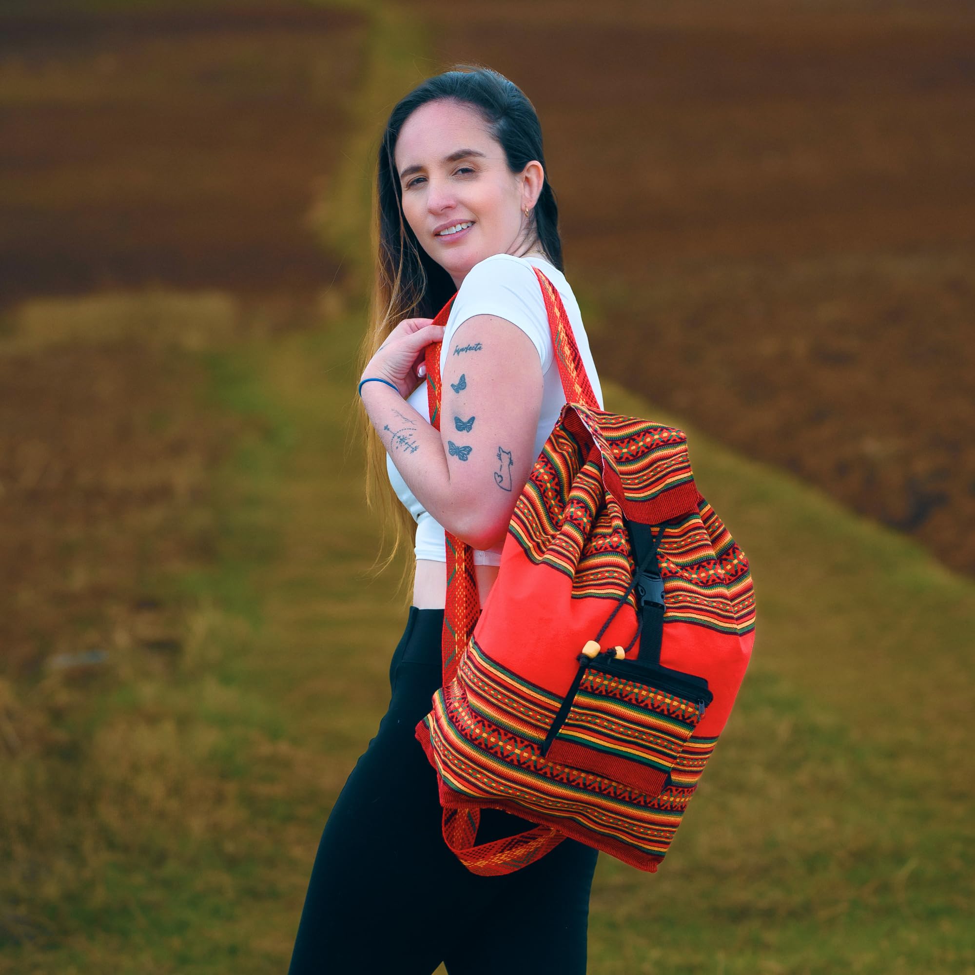 Woman with a colorful backpack standing in a field