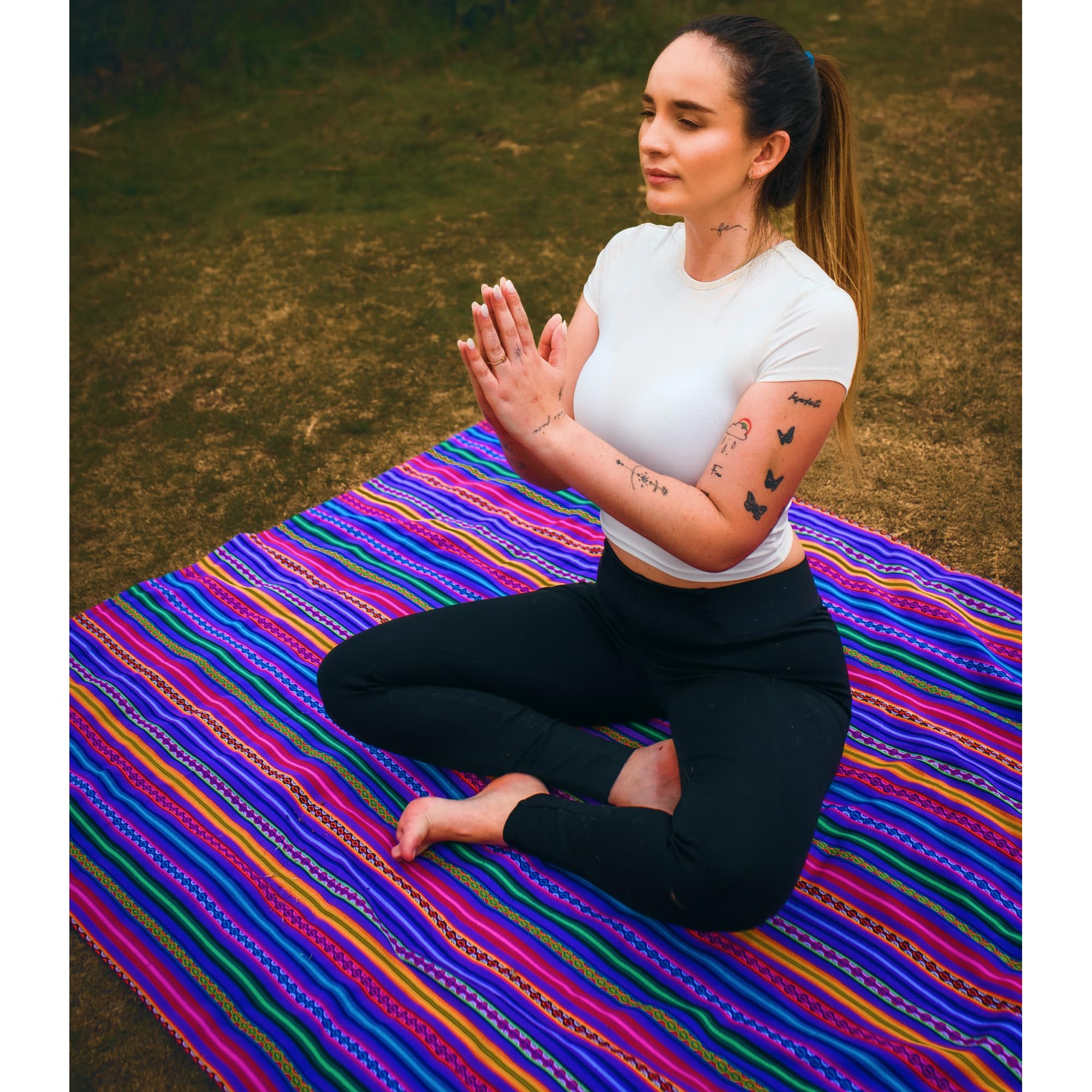 Woman practicing yoga on a colorful mat outdoors