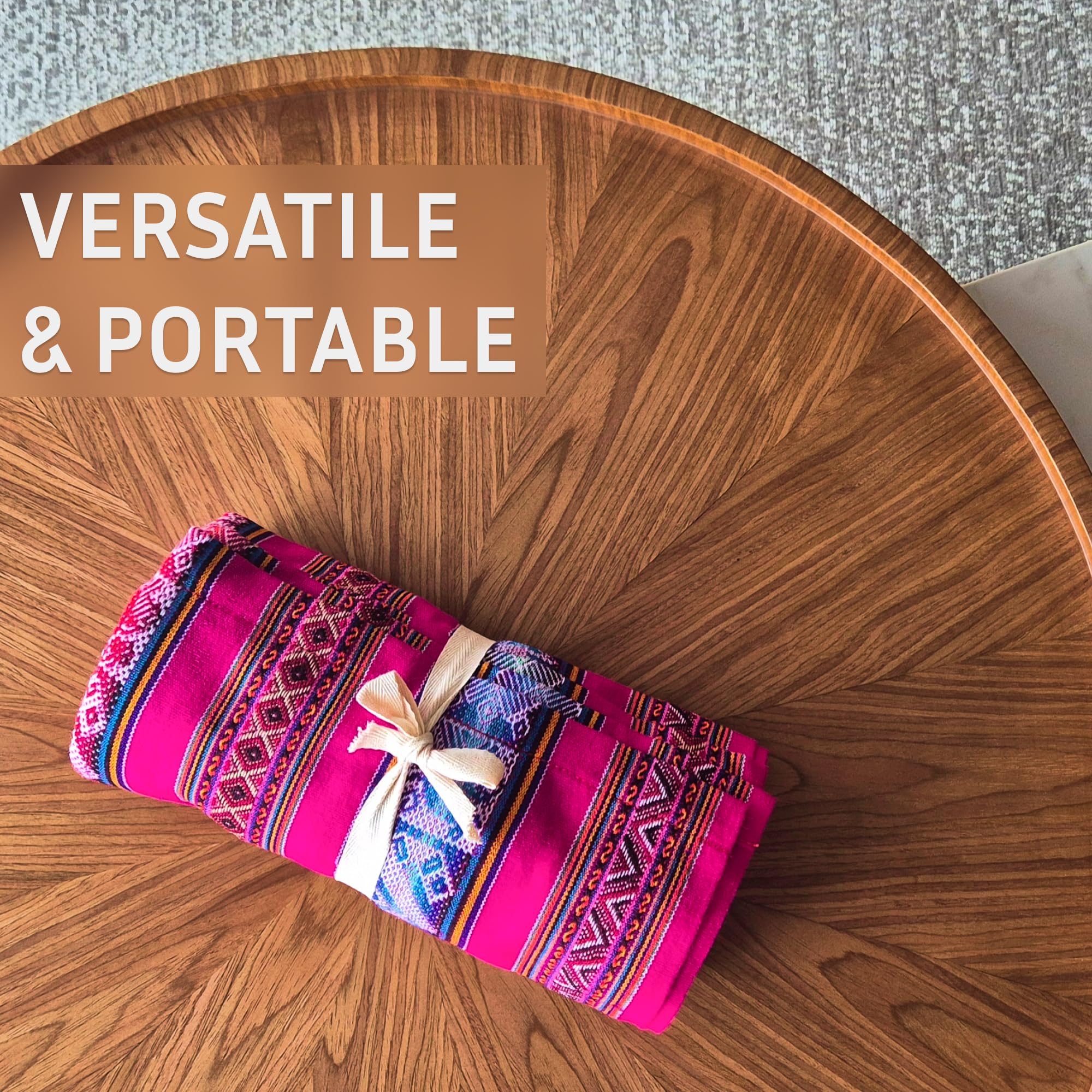 Colorful folded fabric with decorative patterns on a wooden table, labeled 'VERSATILE & PORTABLE'.