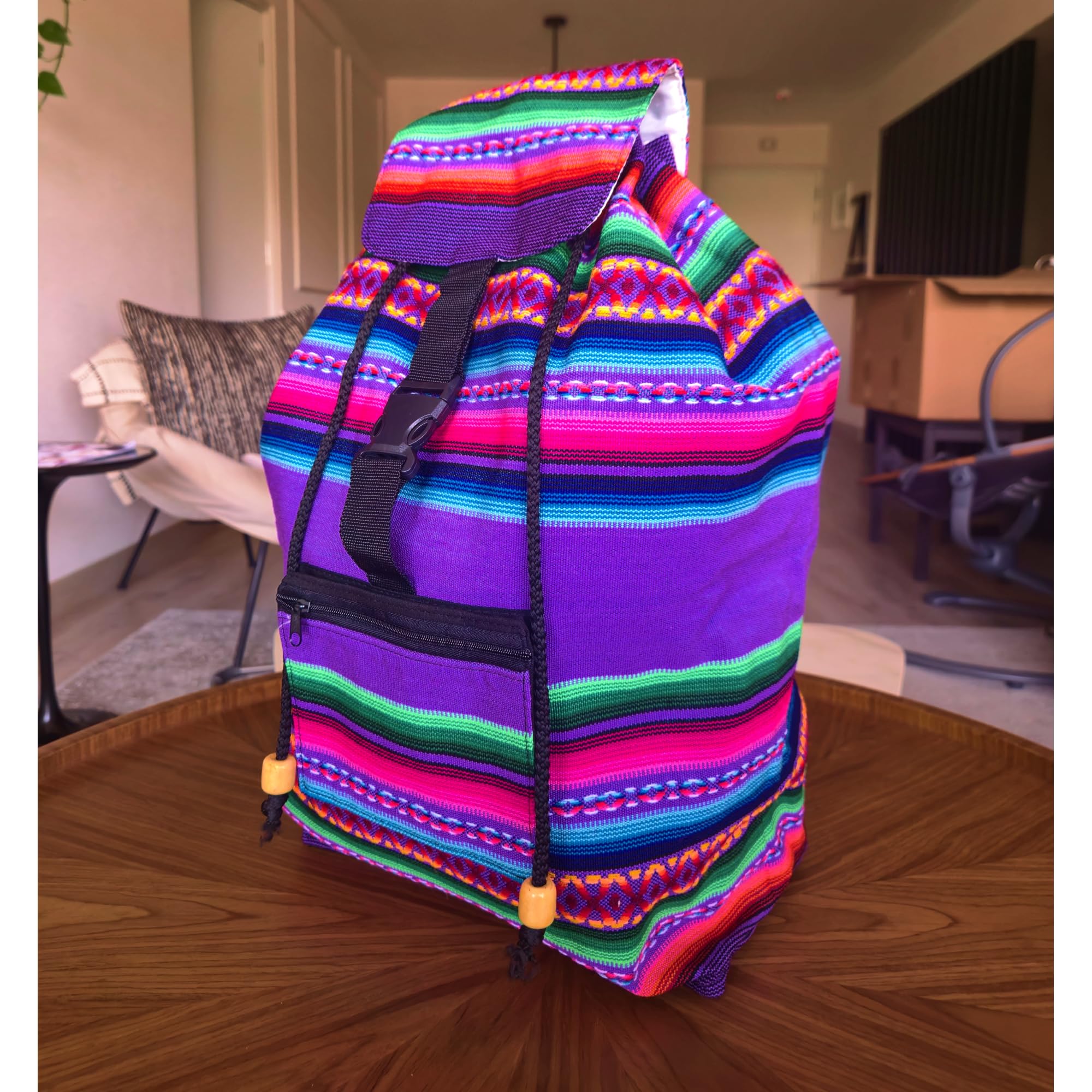 Colorful striped bag on a wooden floor in a room with furniture.